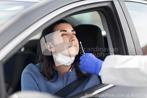 Image of healthcare worker making coronavirus test at car