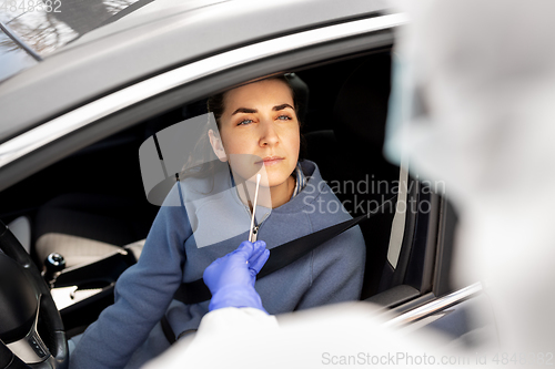 Image of healthcare worker making coronavirus test at car