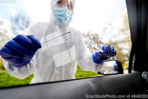 Image of healthcare worker making coronavirus test at car