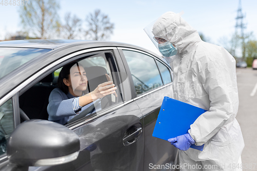 Image of woman in car showing phohe to healthcare worker