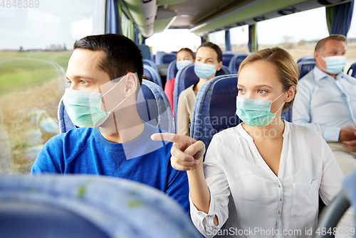 Image of couple of passengers in masks in travel bus