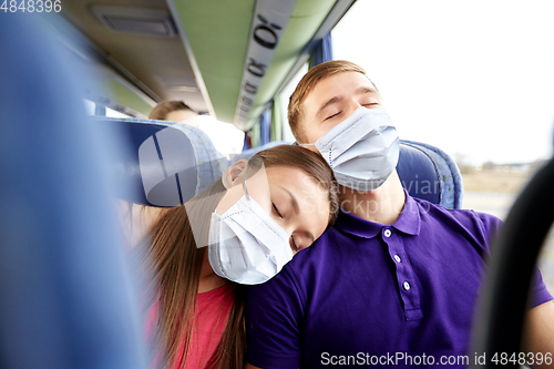 Image of passengers in masks sleeping in travel bus