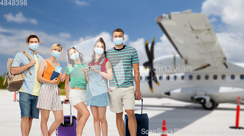 Image of friends in masks with travel bags at airplane