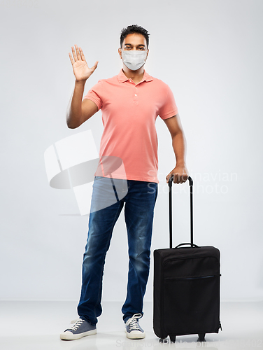 Image of indian man in mask with travel bag waving hand