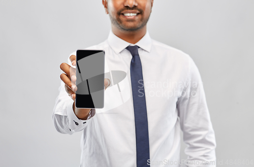 Image of smiling indian businessman showing smartphone