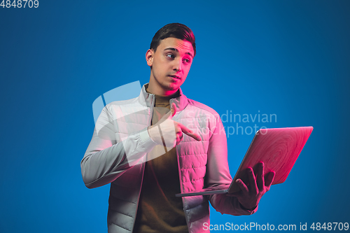 Image of Caucasian man\'s portrait isolated on blue studio background in neon light