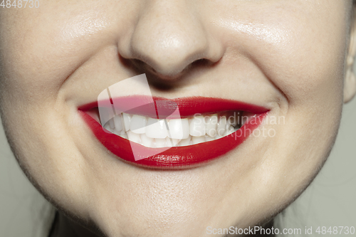 Image of Close-up female mouth with bright red gloss lips make-up. Cosmetology, dentistry and beauty care, emotions