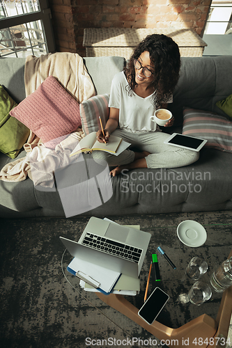 Image of African-american woman, freelancer during the work in home office while quarantine