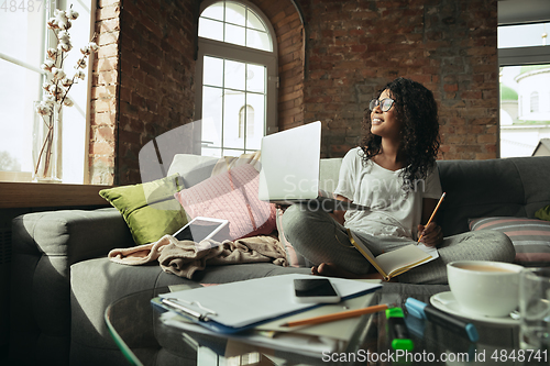 Image of African-american woman, freelancer during the work in home office while quarantine