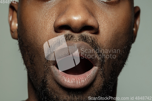 Image of Close up of face of beautiful african-american young man, focus on mouth