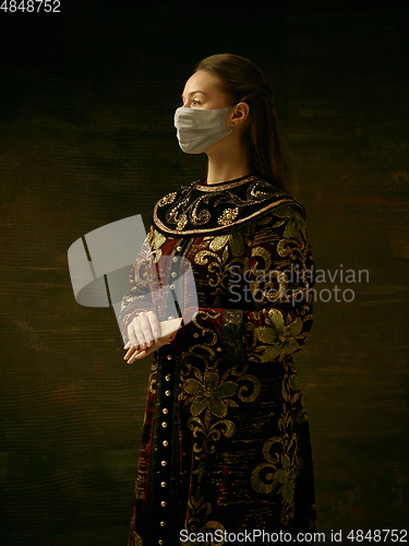 Image of Medieval young woman as a duchess wearing protective mask against coronavirus spread