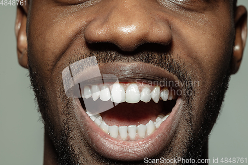 Image of Close up of face of beautiful african-american young man, focus on mouth