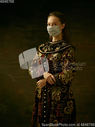 Image of Medieval young woman as a duchess wearing protective mask against coronavirus spread