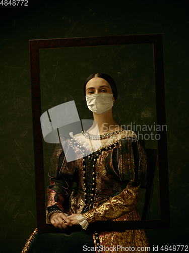 Image of Medieval young woman as a duchess wearing protective mask against coronavirus spread