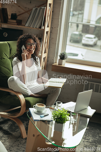 Image of African-american woman, freelancer during the work in home office while quarantine