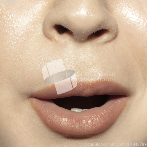 Image of Close-up female mouth with natural nude gloss lips make-up. Cosmetology, dentistry and beauty care, emotions