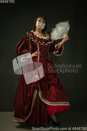 Image of Medieval young woman as a duchess wearing protective mask against coronavirus spread