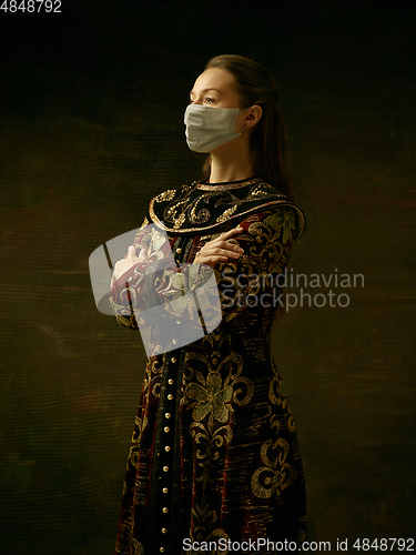 Image of Medieval young woman as a duchess wearing protective mask against coronavirus spread