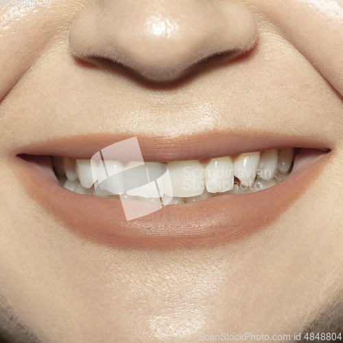 Image of Close-up female mouth with natural nude gloss lips make-up. Cosmetology, dentistry and beauty care, emotions