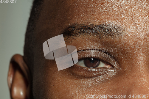 Image of Close up of face of beautiful african-american young man, focus on eyes