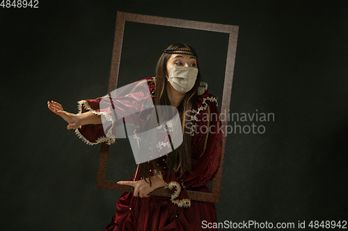 Image of Medieval young woman as a duchess wearing protective mask against coronavirus spread