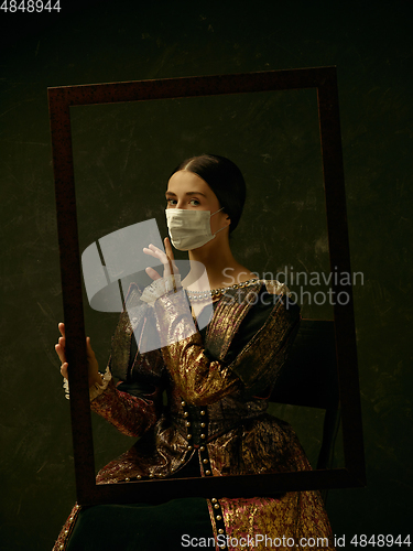 Image of Medieval young woman as a duchess wearing protective mask against coronavirus spread