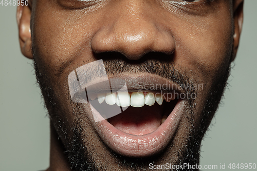 Image of Close up of face of beautiful african-american young man, focus on mouth