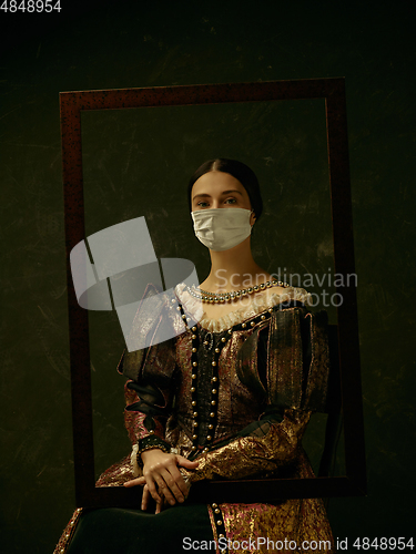 Image of Medieval young woman as a duchess wearing protective mask against coronavirus spread