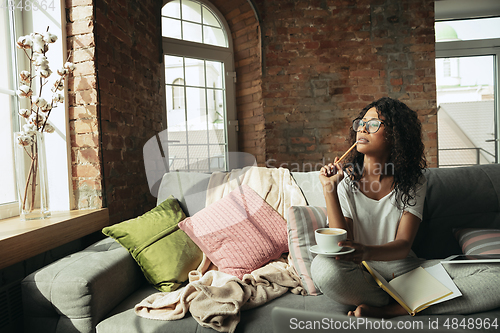 Image of African-american woman, freelancer during the work in home office while quarantine