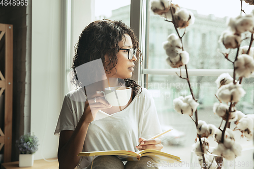 Image of African-american woman, freelancer during the work in home office while quarantine