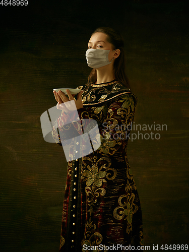 Image of Medieval young woman as a duchess wearing protective mask against coronavirus spread