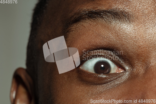 Image of Close up of face of beautiful african-american young man, focus on eyes