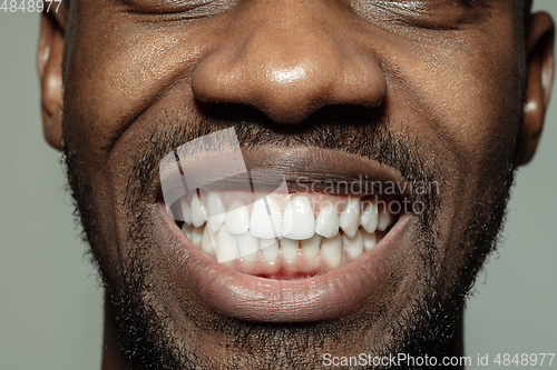 Image of Close up of face of beautiful african-american young man, focus on mouth