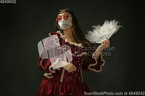 Image of Medieval young woman as a duchess wearing protective mask against coronavirus spread