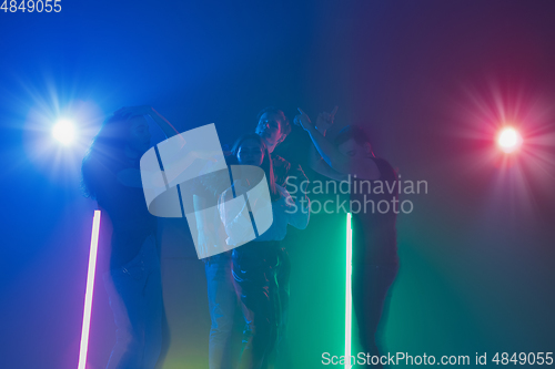 Image of Cheering dance party, performance concept. Crowd shadow of people dancing with neon lights raised hands up