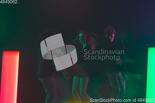 Image of Cheering dance party, performance concept. Crowd shadow of people dancing with neon lights raised hands up