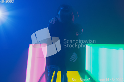 Image of Cheering dance party, performance concept. Couple hugging in neon lights, romantic and lovely