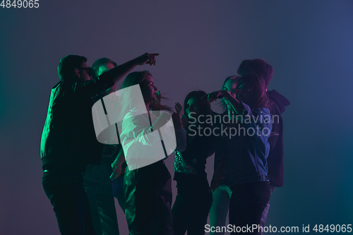 Image of Cheering dance party, performance concept. Crowd shadow of people dancing with neon lights raised hands up