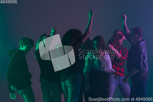 Image of Cheering dance party, performance concept. Crowd shadow of people dancing with neon lights raised hands up