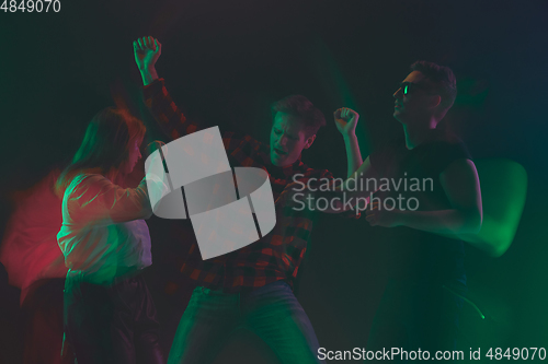 Image of Cheering dance party, performance concept. Crowd shadow of people dancing with neon lights raised hands up