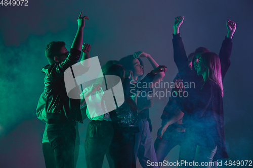 Image of Cheering dance party, performance concept. Crowd shadow of people dancing with neon lights raised hands up