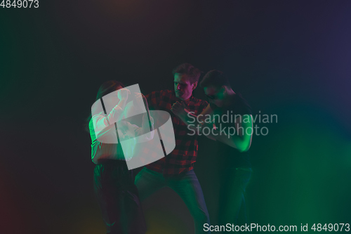 Image of Cheering dance party, performance concept. Crowd shadow of people dancing with neon lights raised hands up