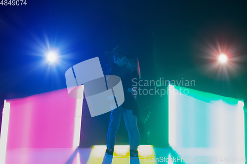 Image of Cheering dance party, performance concept. Couple hugging in neon lights, romantic and lovely