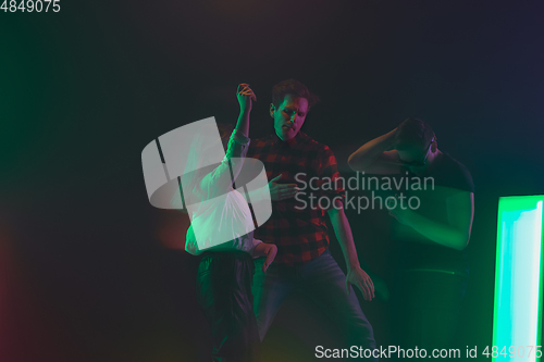 Image of Cheering dance party, performance concept. Crowd shadow of people dancing with neon lights raised hands up