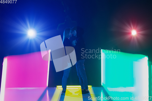 Image of Cheering dance party, performance concept. Couple hugging in neon lights, romantic and lovely