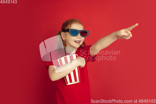 Image of Caucasian little girl portrait isolated on red studio background, emotions concept