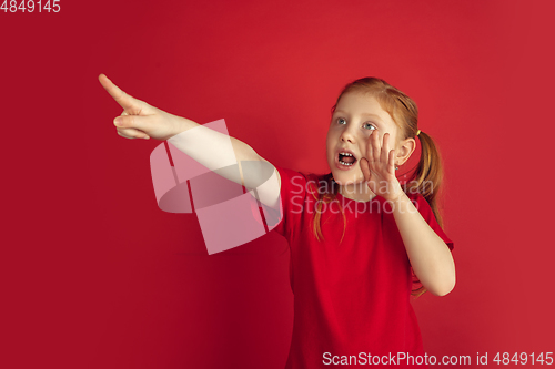 Image of Caucasian little girl portrait isolated on red studio background, emotions concept