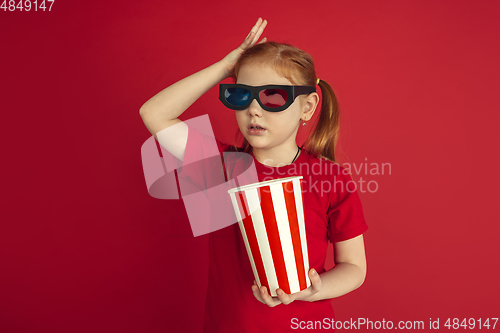 Image of Caucasian little girl portrait isolated on red studio background, emotions concept