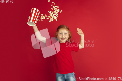 Image of Caucasian little girl portrait isolated on red studio background, emotions concept