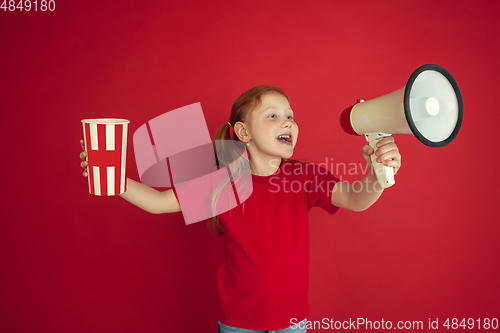 Image of Caucasian little girl portrait isolated on red studio background, emotions concept